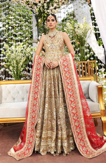 A model wearing an ornate gold-embroidered bridal dress by Maryum N Maria, featuring intricate zardozi work and embellishments, paired with a long red and gold heavily detailed dupatta draped over her arms.